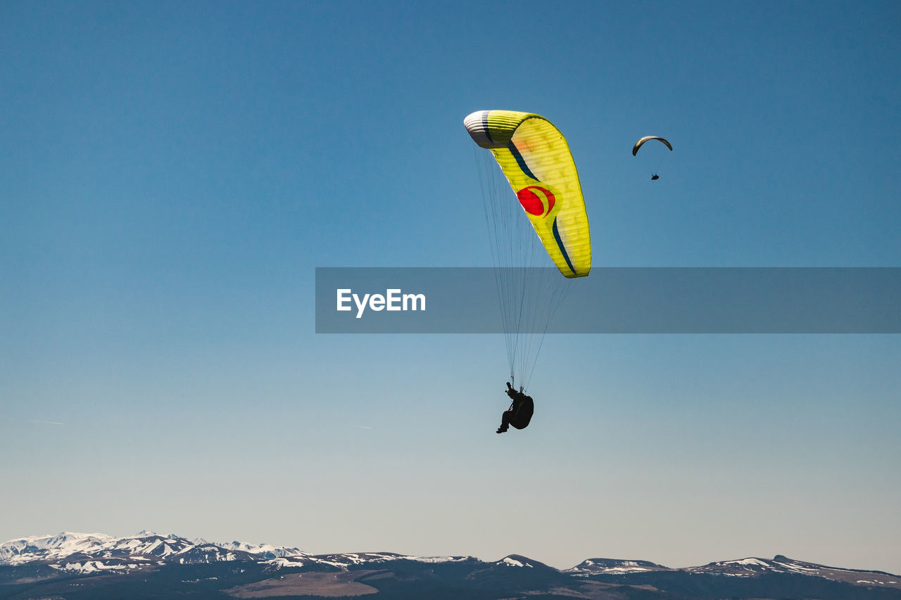 PERSON PARAGLIDING AGAINST SKY