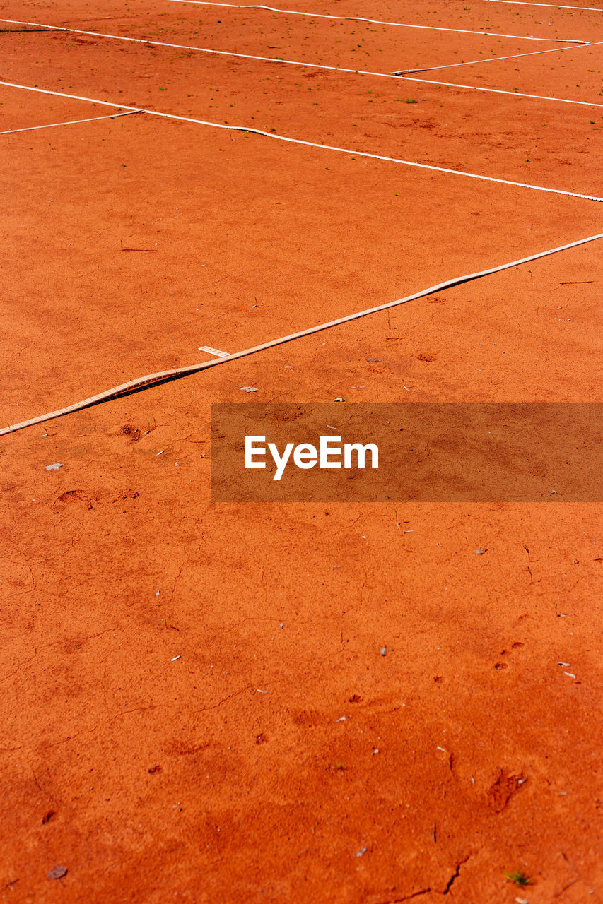 High angle view of lines on orange dirt at playing field