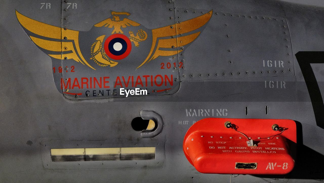 Logo of fighter plane, close-up red text on metal