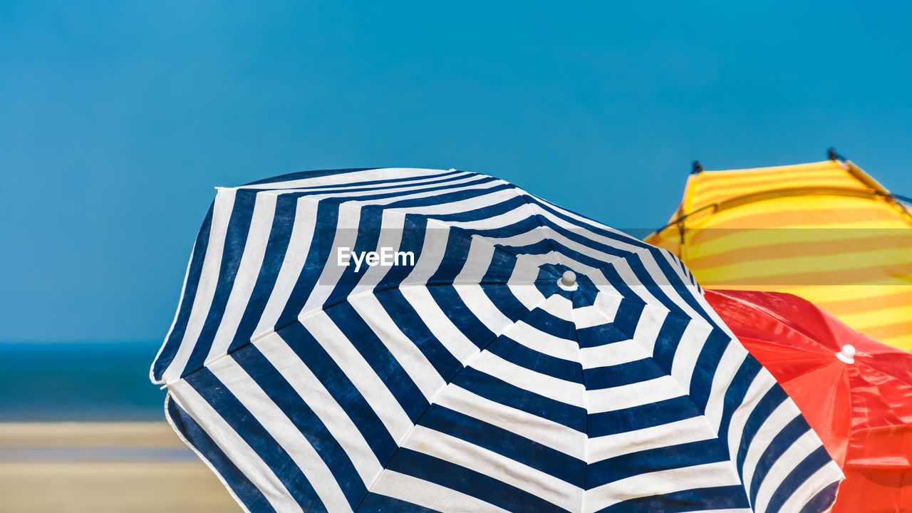 Striped beach umbrellas in a sunny day