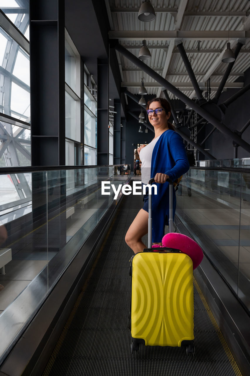 FULL LENGTH OF WOMAN ON ESCALATOR