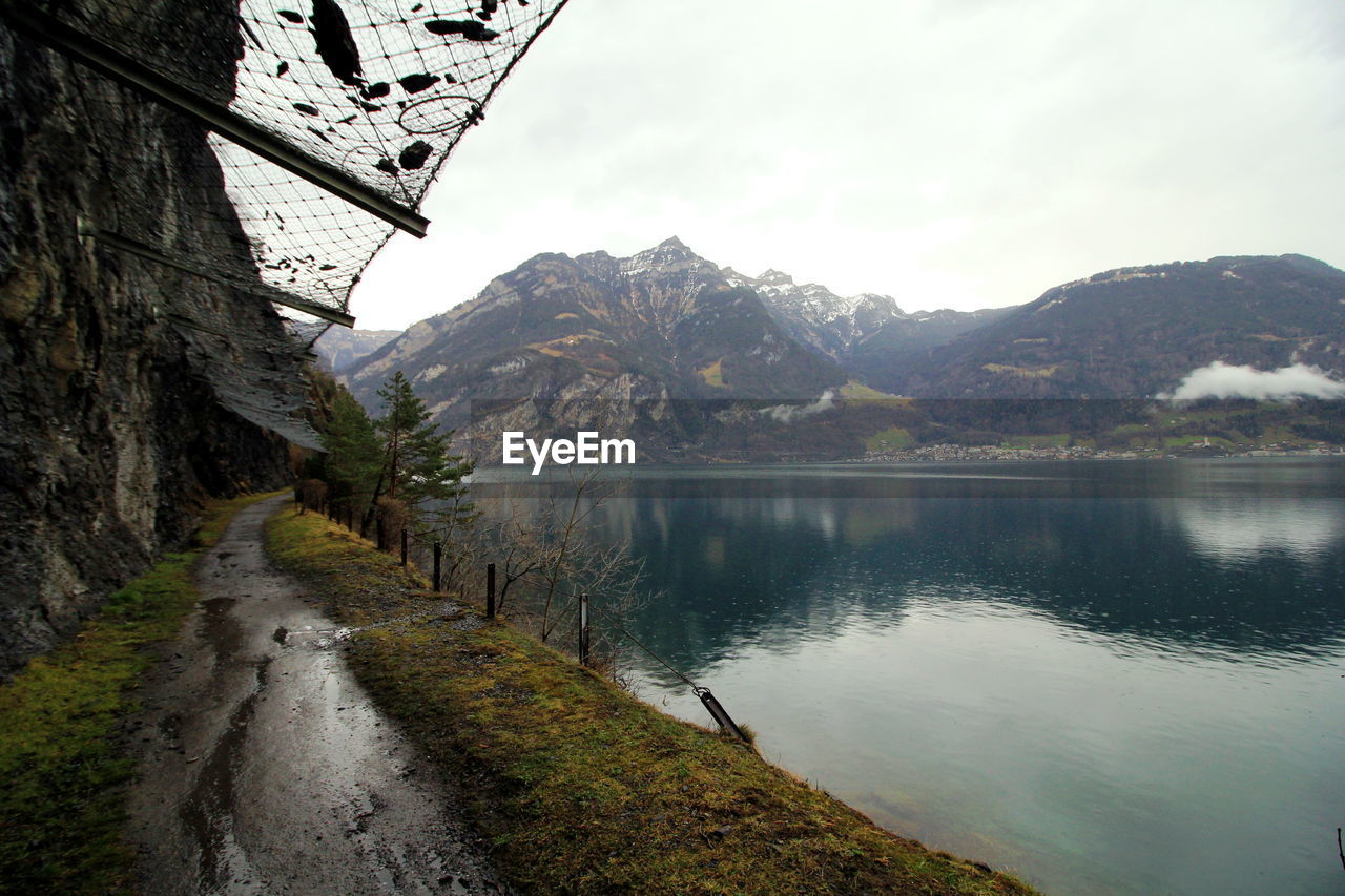 Scenic view of lake by mountains against sky