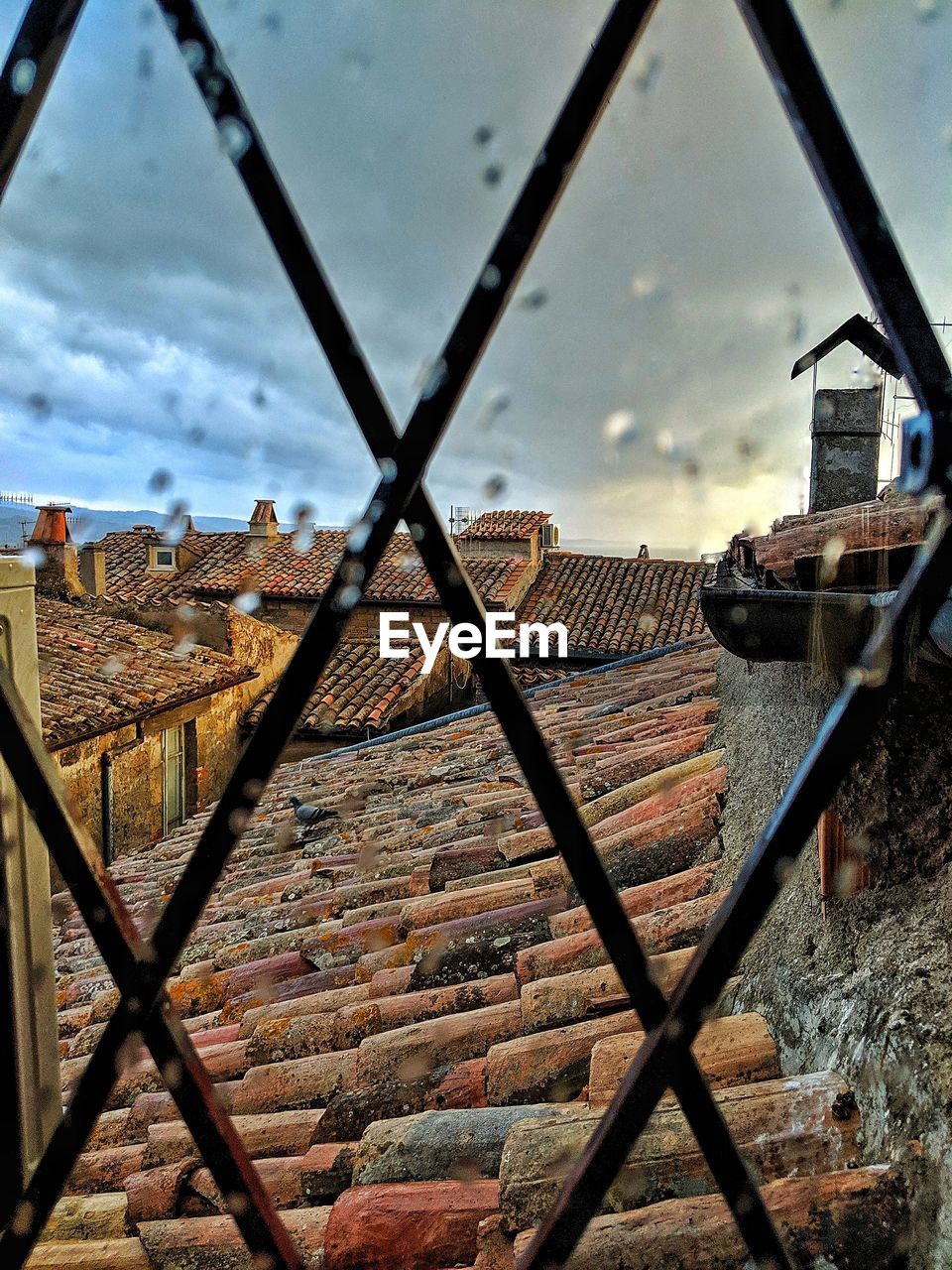 OLD BUILDINGS SEEN THROUGH CHAINLINK FENCE