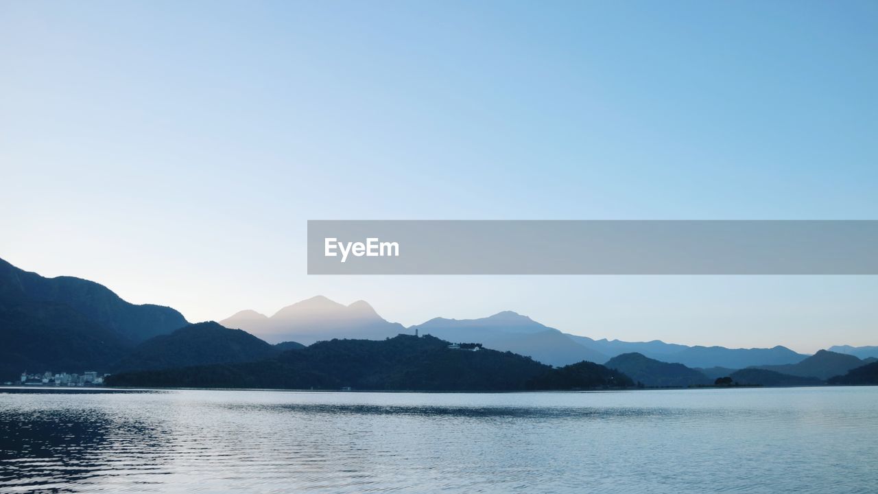 Scenic view of lake and mountains against clear sky