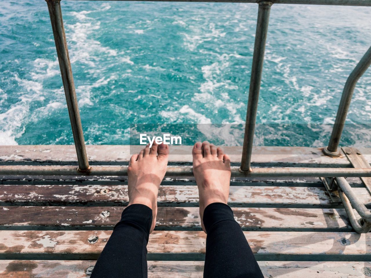 Low section of person sitting on boat in sea