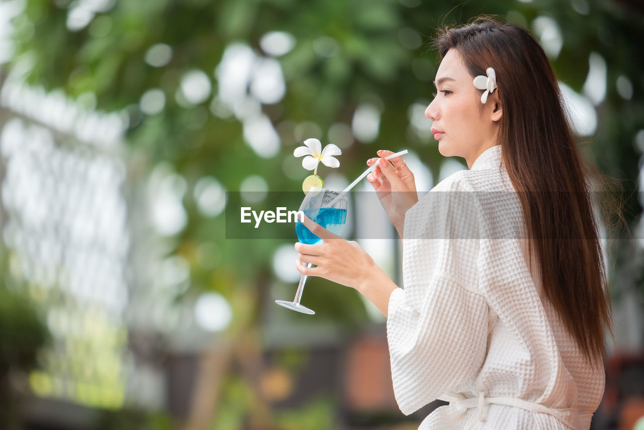 SIDE VIEW OF WOMAN DRINKING GLASS