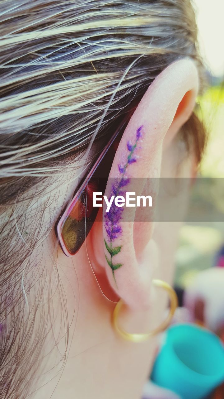 Close-up of woman with tattoo on ear