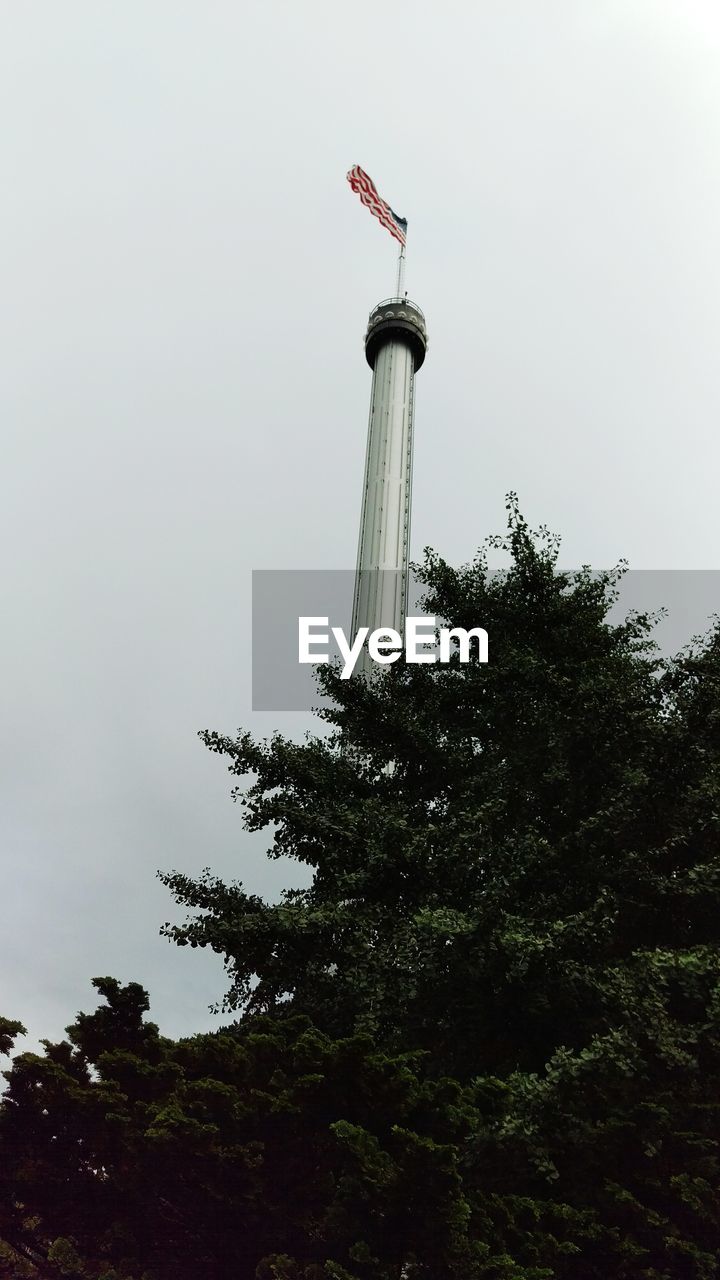 Low angle view of tree by american flag against sky