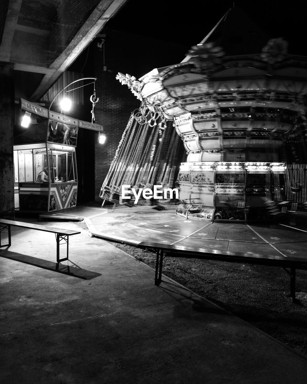 EMPTY CHAIRS AND TABLE IN ILLUMINATED AT NIGHT