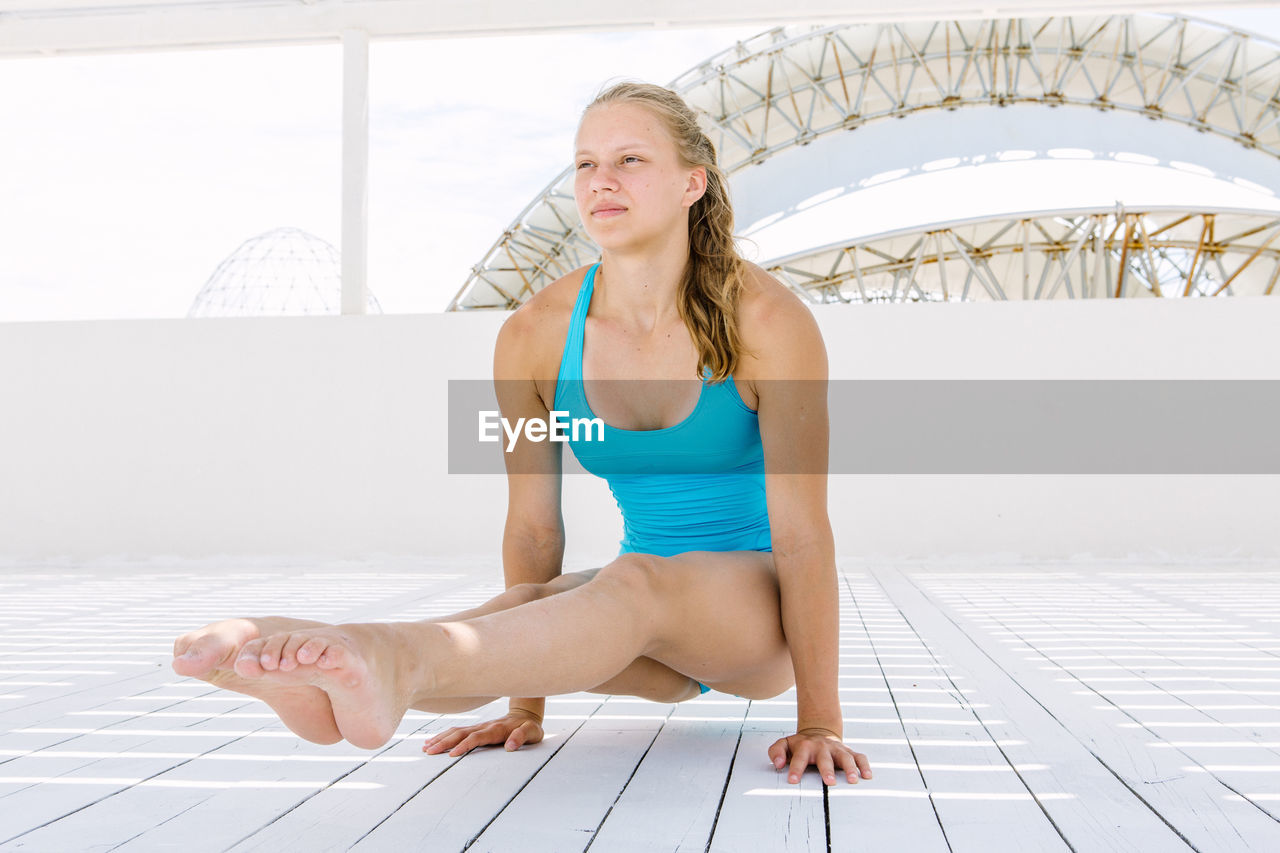 Young woman doing yoga on floor