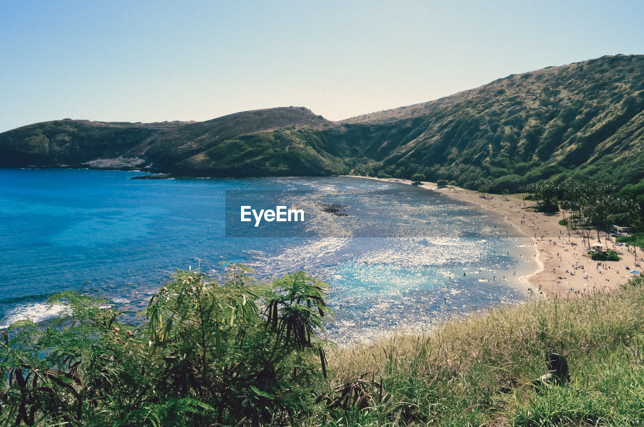 Scenic view of sea and mountains against clear sky