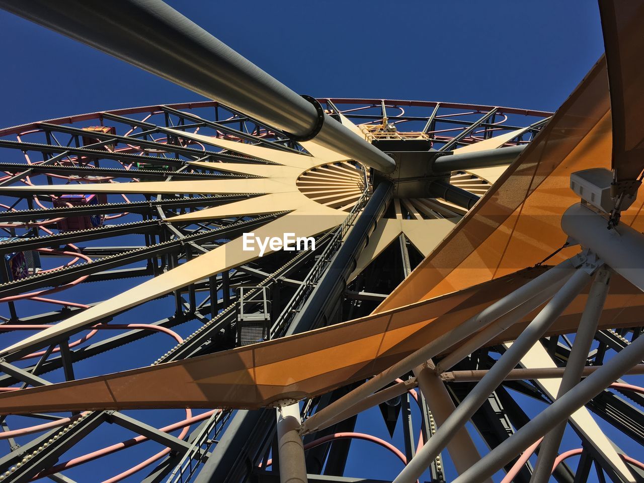 Low angle view of ferris wheel against clear blue sky