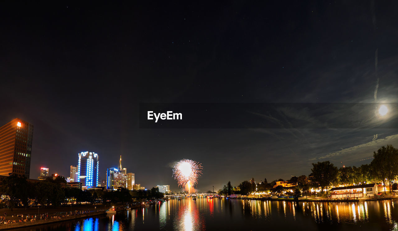 Fireworks against sky in city at night