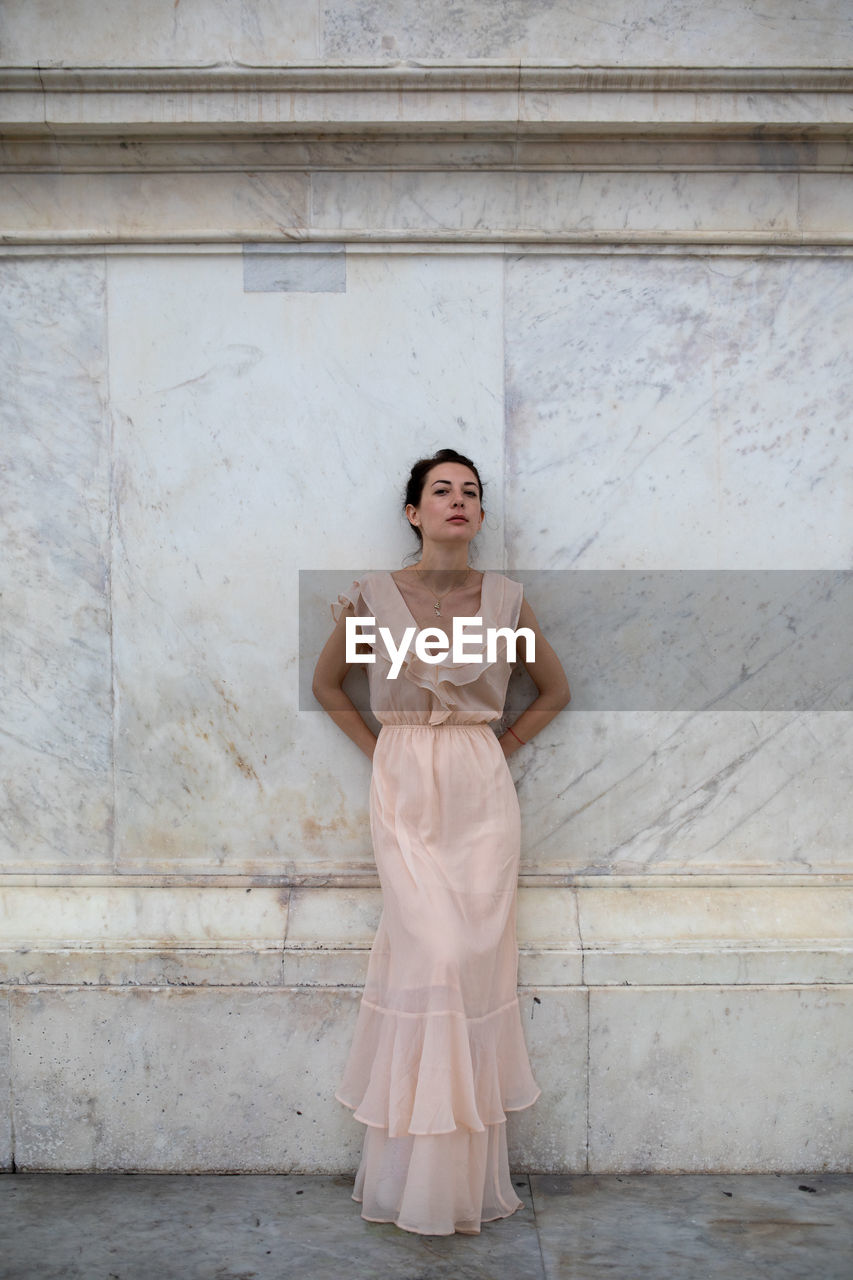 Portrait of beautiful woman standing against wall