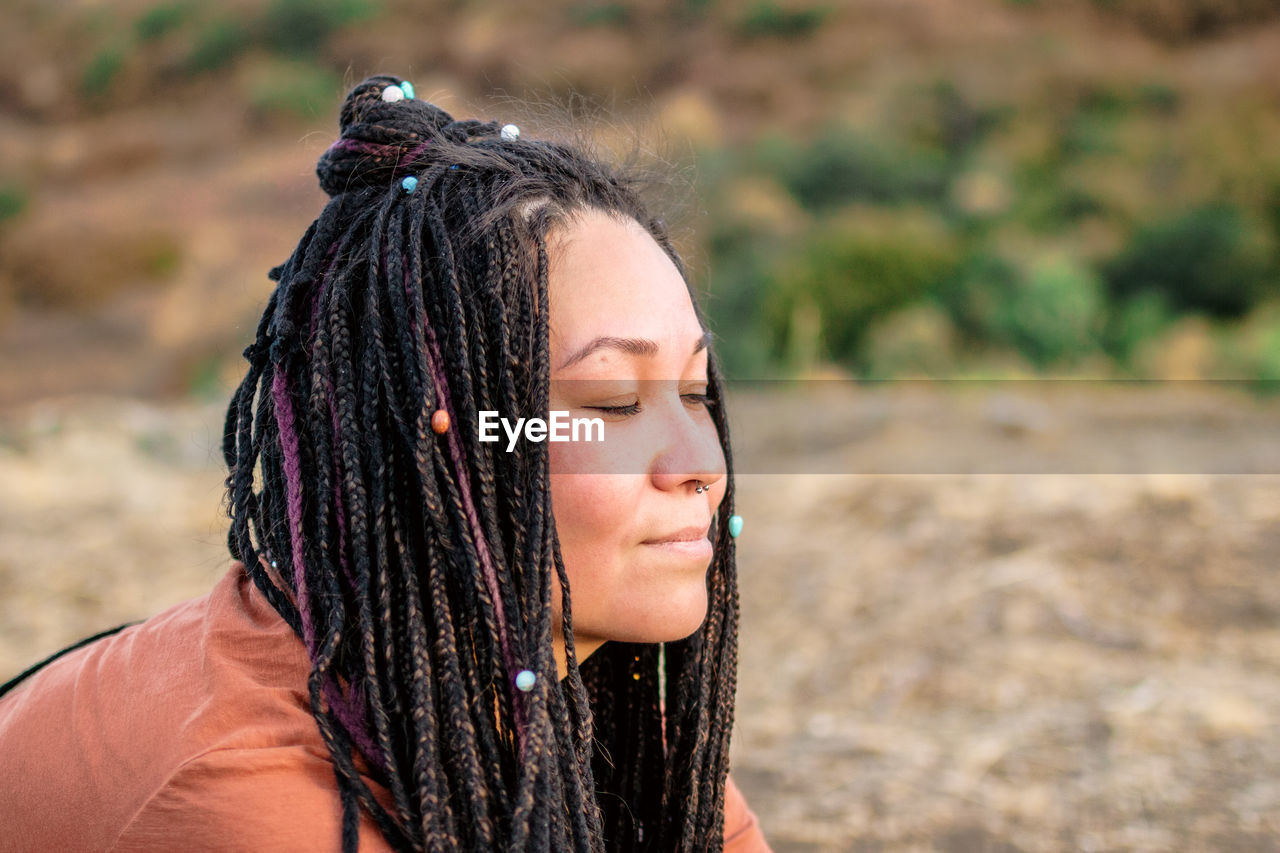Close up portrait of beautiful european woman with long african braids and closed eyes. 