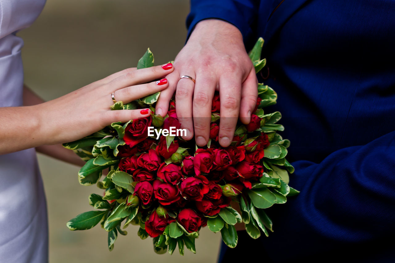 Close-up mid section of newly wed with bouquet