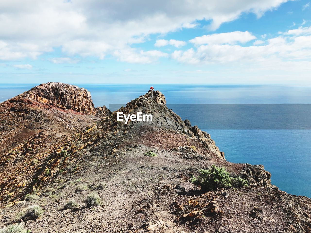 Rock formations by sea against sky