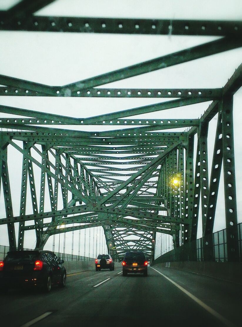 Cars moving on bridge against clear sky