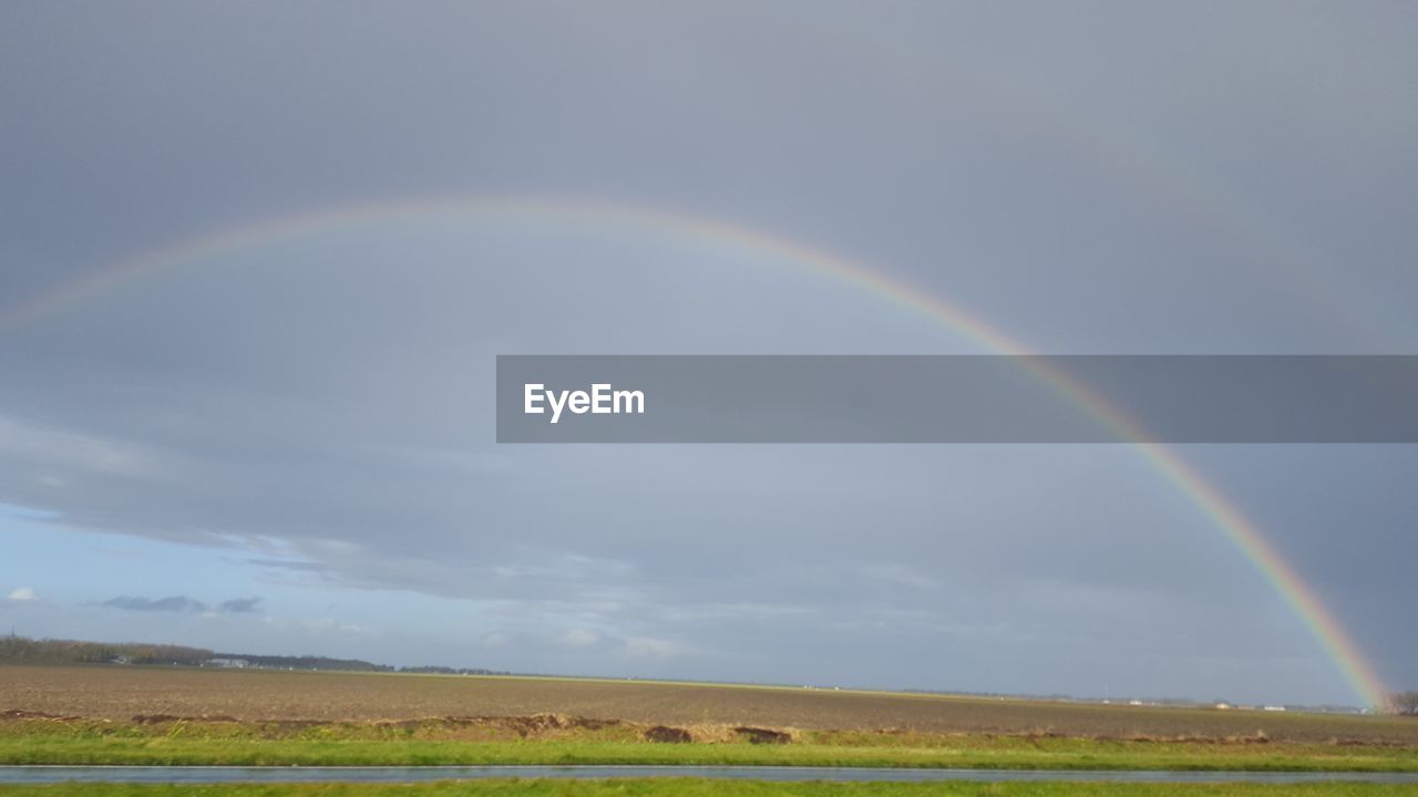 SCENIC VIEW OF RAINBOW OVER FIELD