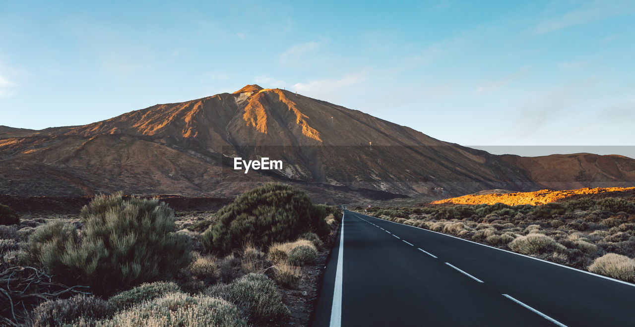 Road by mountain against sky