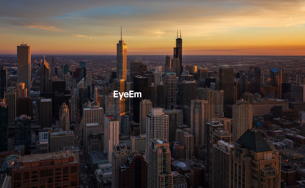 Aerial view of buildings in city during sunset