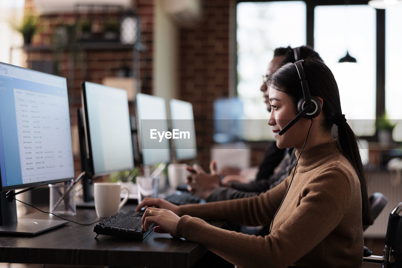 Customer service representative with colleague working at desk