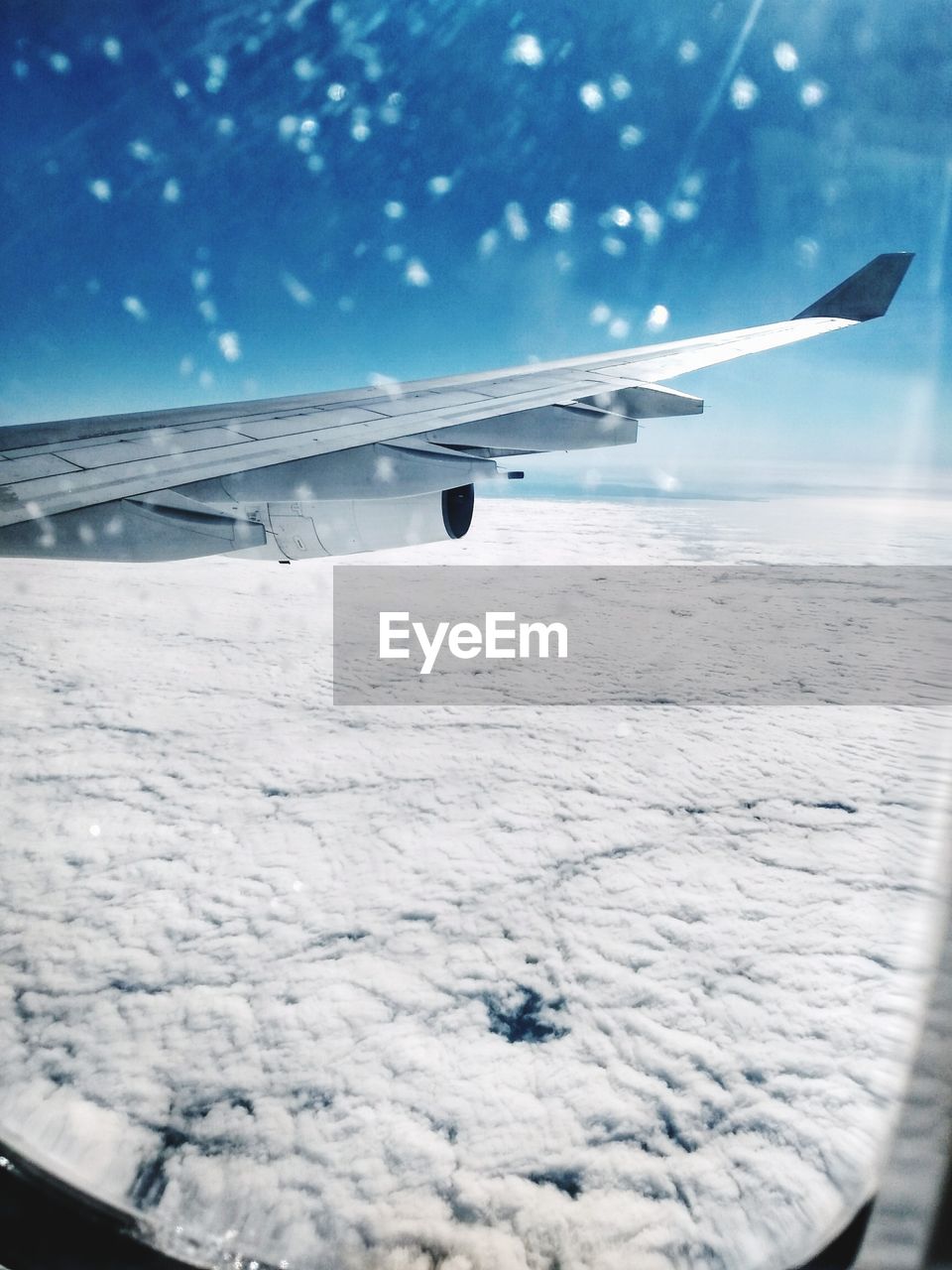 AIRPLANE FLYING OVER SNOW COVERED LANDSCAPE