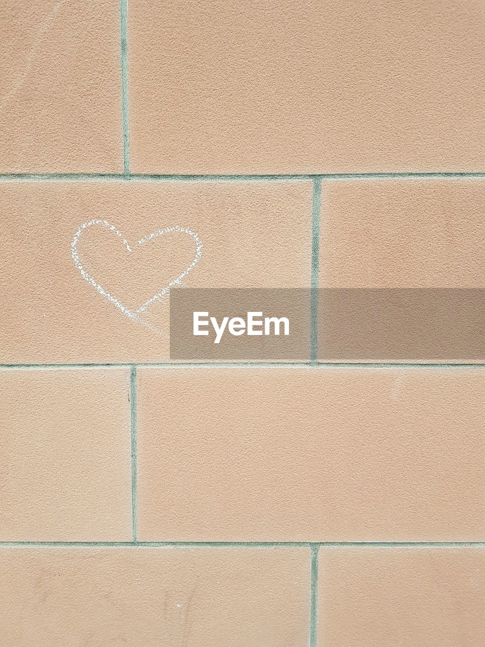 Close-up of heart shape on brick wall