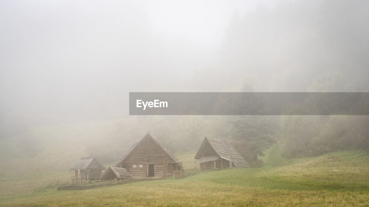 Ancient wooden huts in foggy forest, slovakia, europe