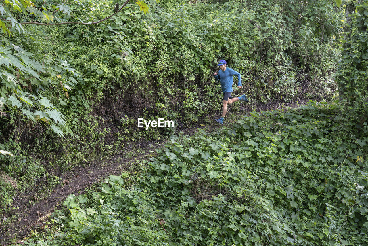 One man running down on a trail surrounded by vegetation in zacatlan