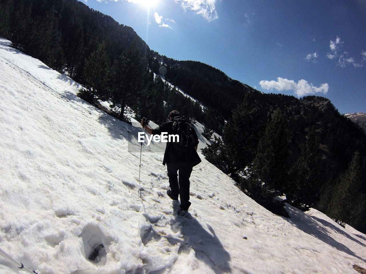 FULL LENGTH REAR VIEW OF MAN WALKING ON SNOW COVERED MOUNTAIN