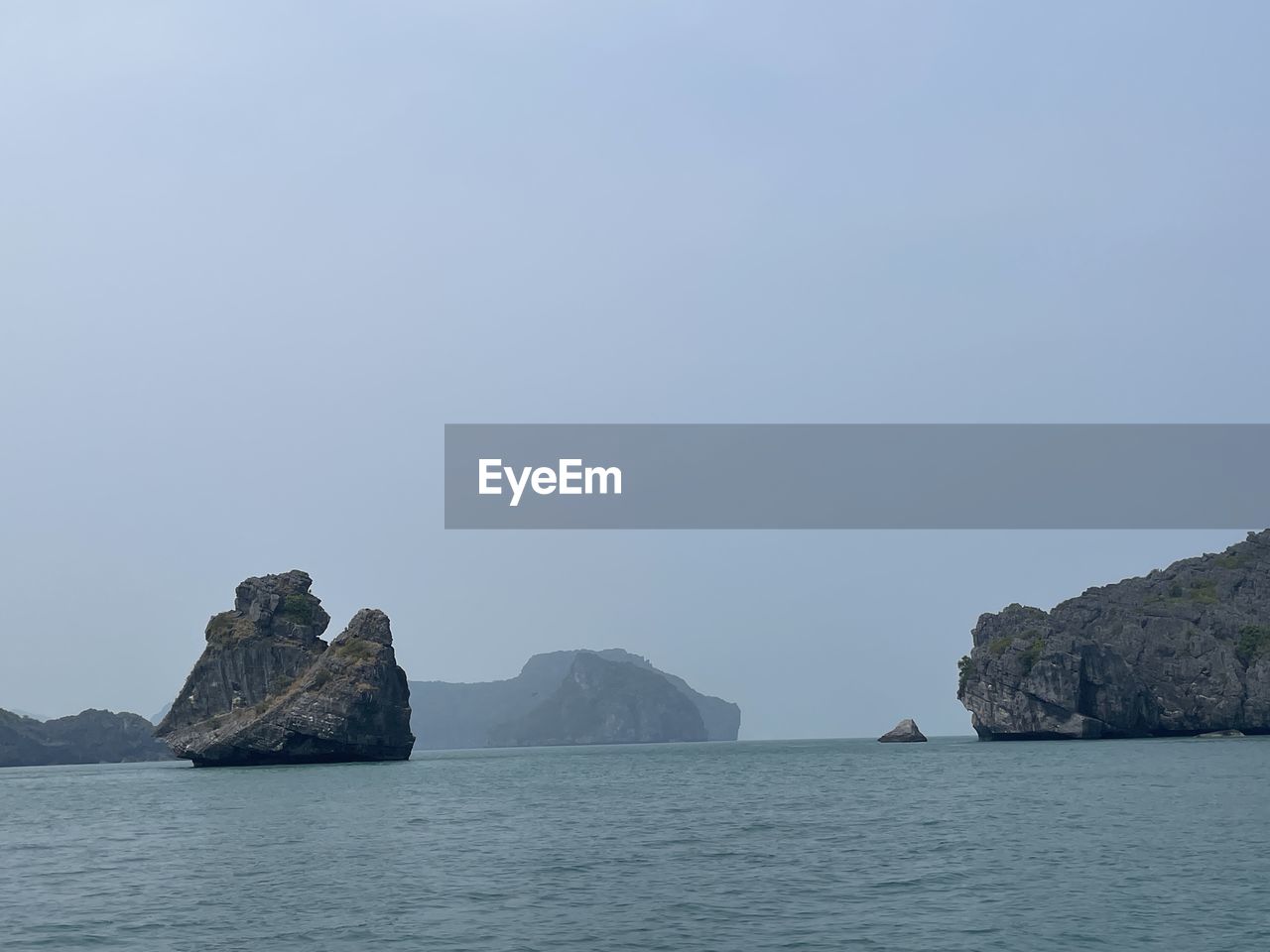 rocks on sea against clear sky