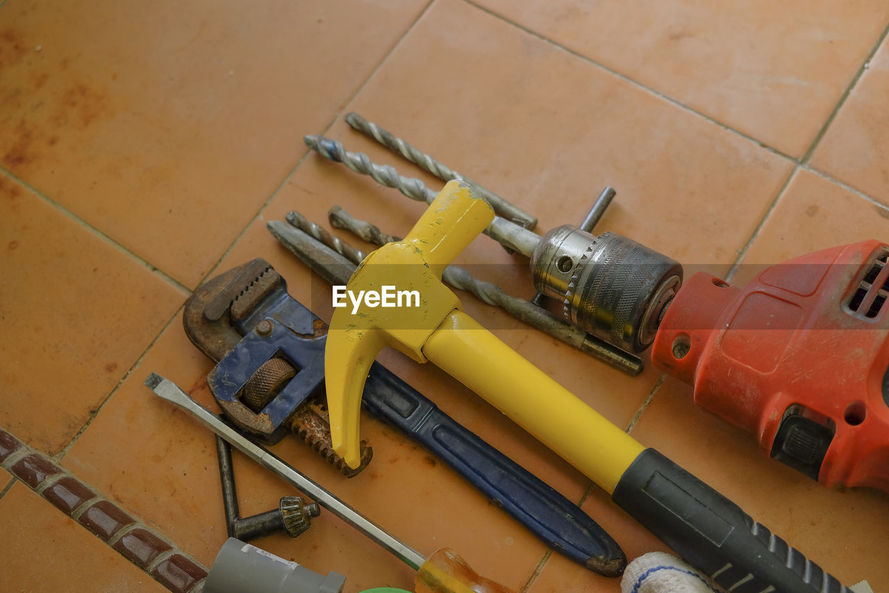 High angle view of work tools on tiled floor