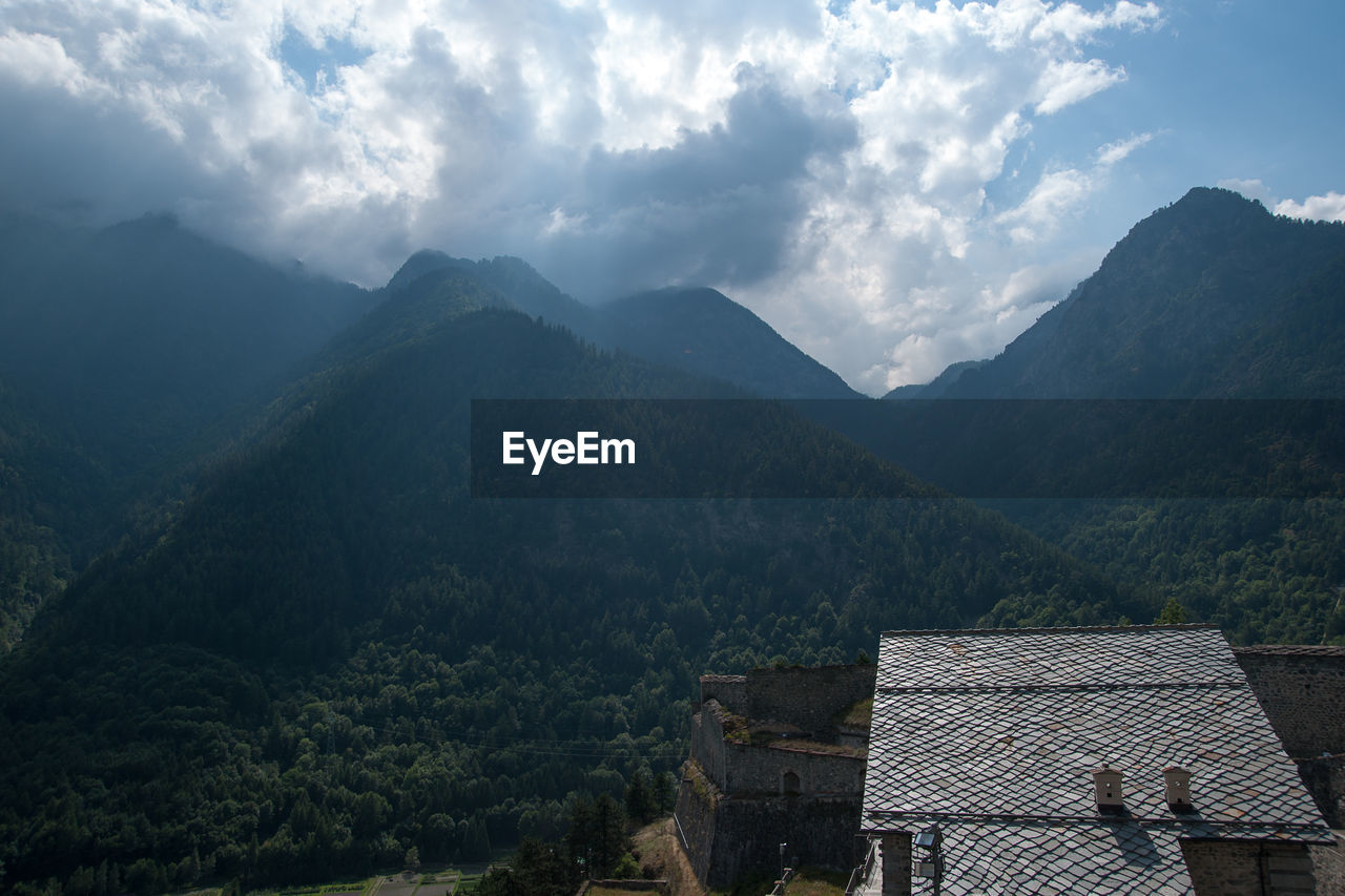 Scenic view of mountains and houses against sky