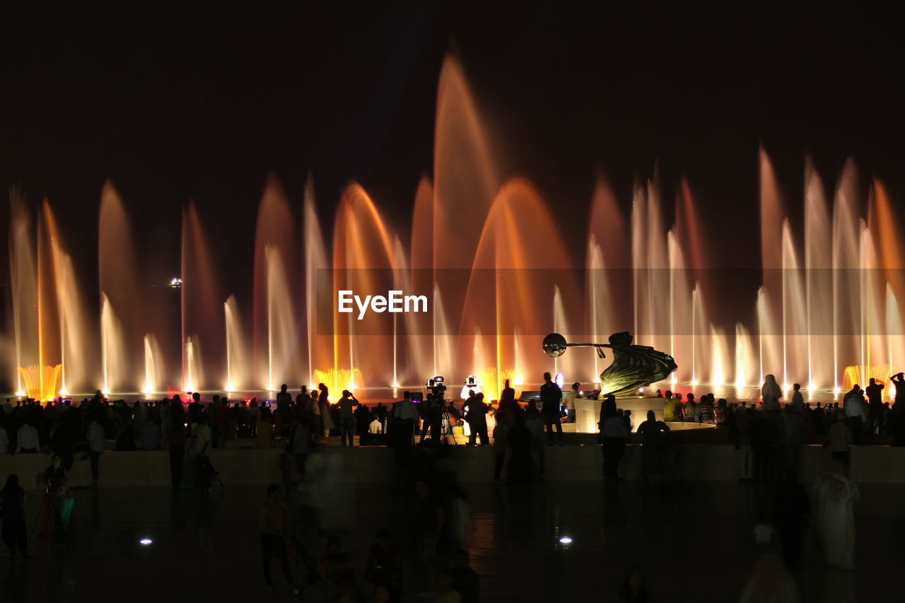 Illuminated fountains at event during night