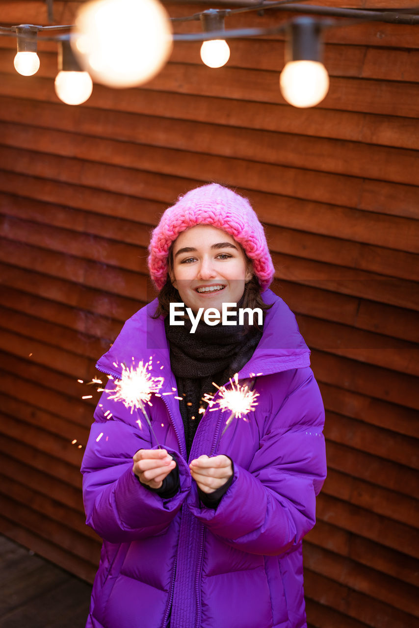 Portrait of young woman in puff with sparklers in her hands smiling cute