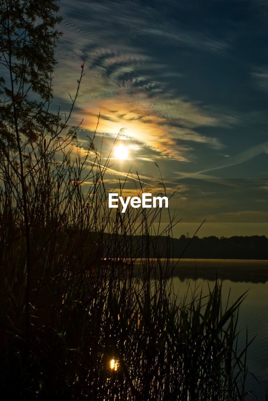 SCENIC VIEW OF LAKE AGAINST SKY AT SUNSET