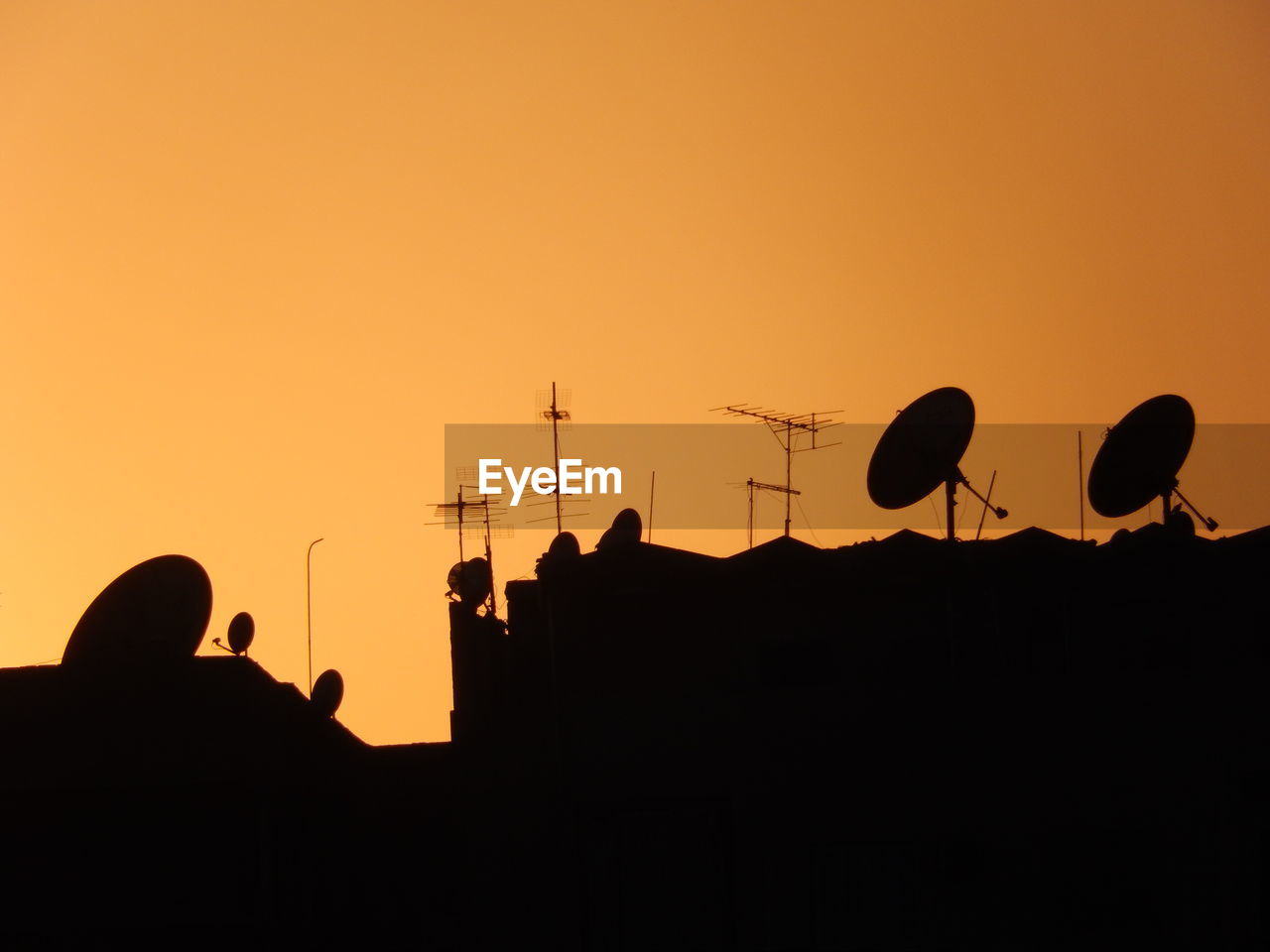 Low angle view of silhouette houses against sky during sunset