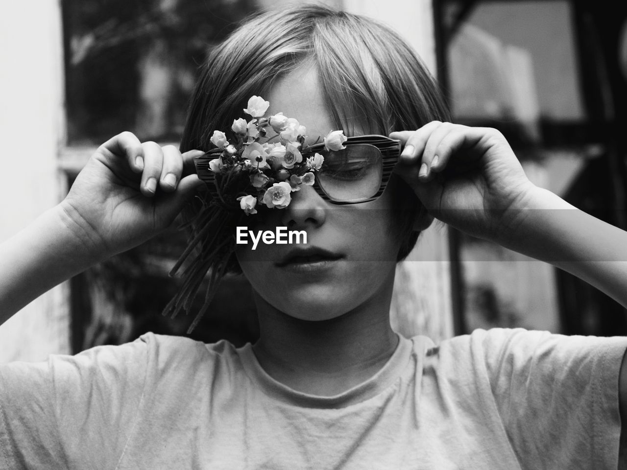 Close-up of cute boy wearing eyeglasses while holding flower