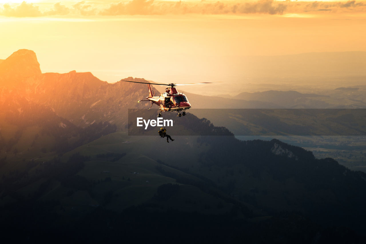 Silhouette man jumping from helicopter