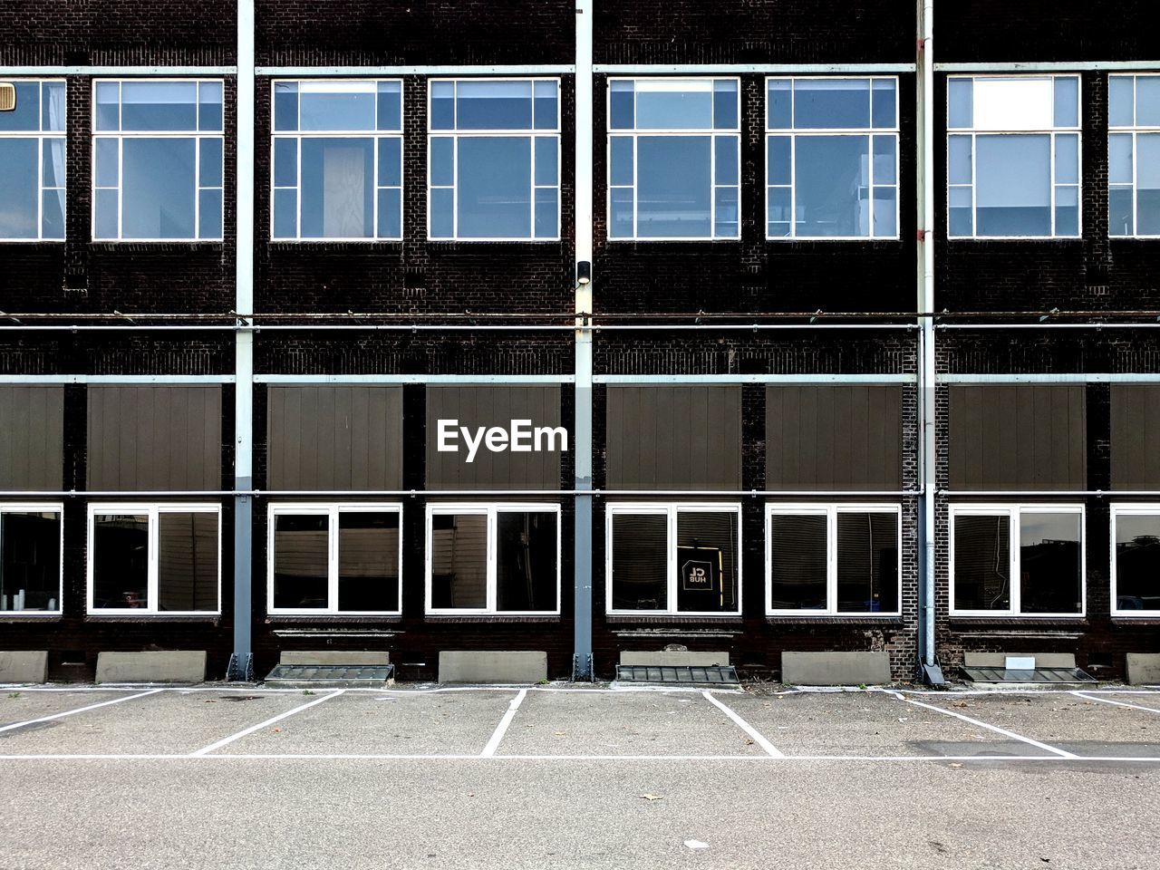 Windows of an industrial building and parking lot.