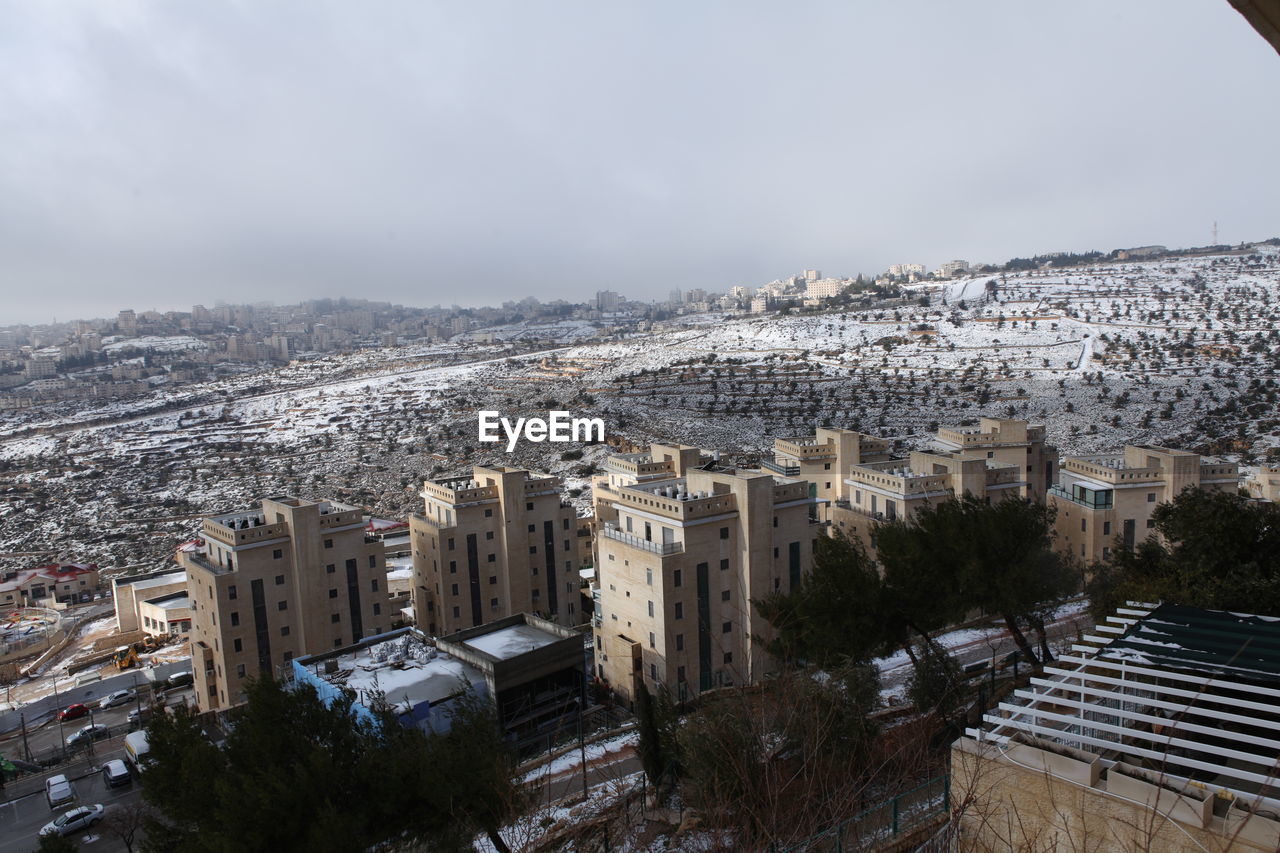 architecture, built structure, building exterior, city, snow, building, urban area, cityscape, sky, winter, aerial photography, nature, high angle view, landscape, travel destinations, skyline, cold temperature, no people, residential district, landmark, town, outdoors, travel, downtown, skyscraper, cloud, environment, tourism, urban skyline, day