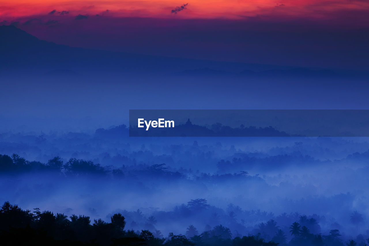 Borobudur silhouette trees against sky during sunset