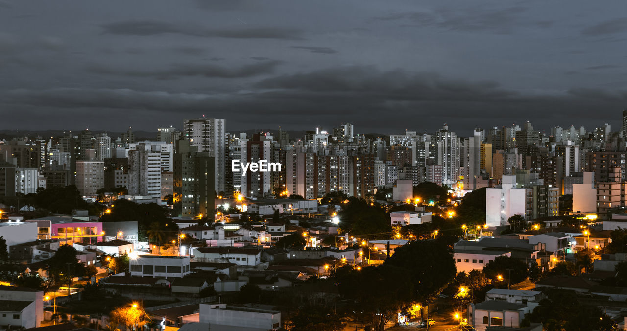 High angle view of illuminated buildings against sky at night