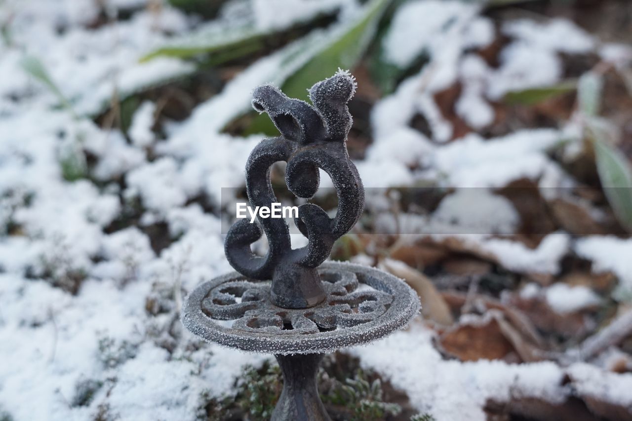 CLOSE-UP OF FROZEN METAL ON SNOW