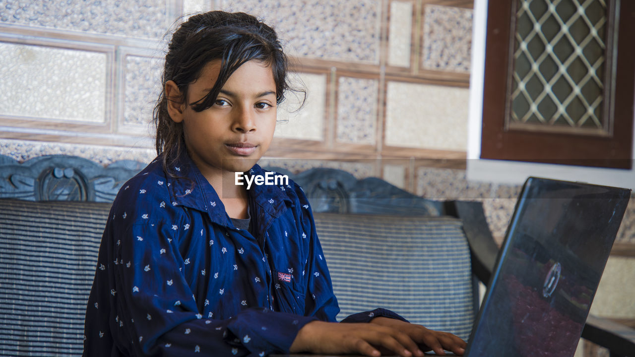 Portrait of girl using laptop at home