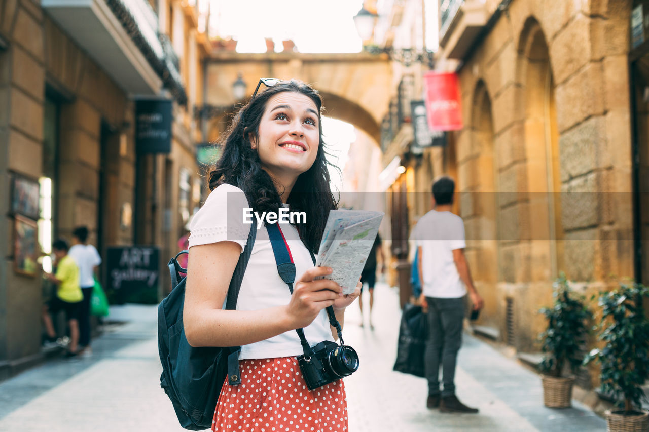 Young woman standing on street in city