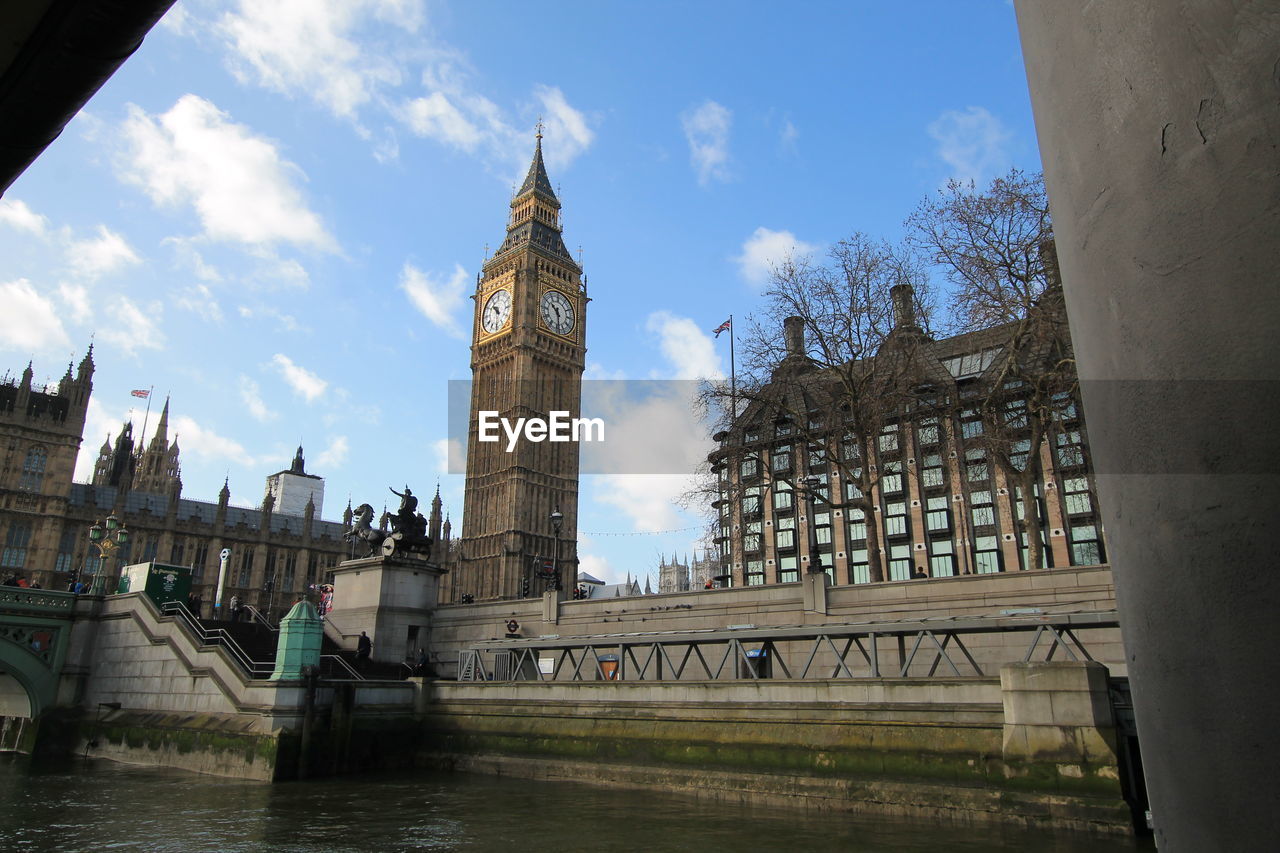 Thames river by big ben against sky