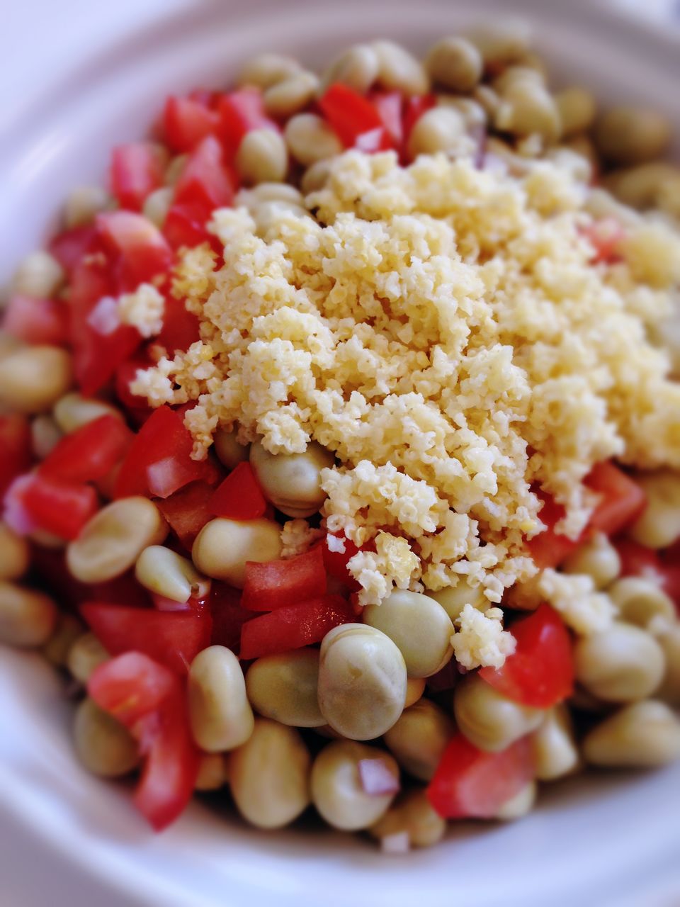 Close-up of cooked sorghum with tomato and bean in bowl