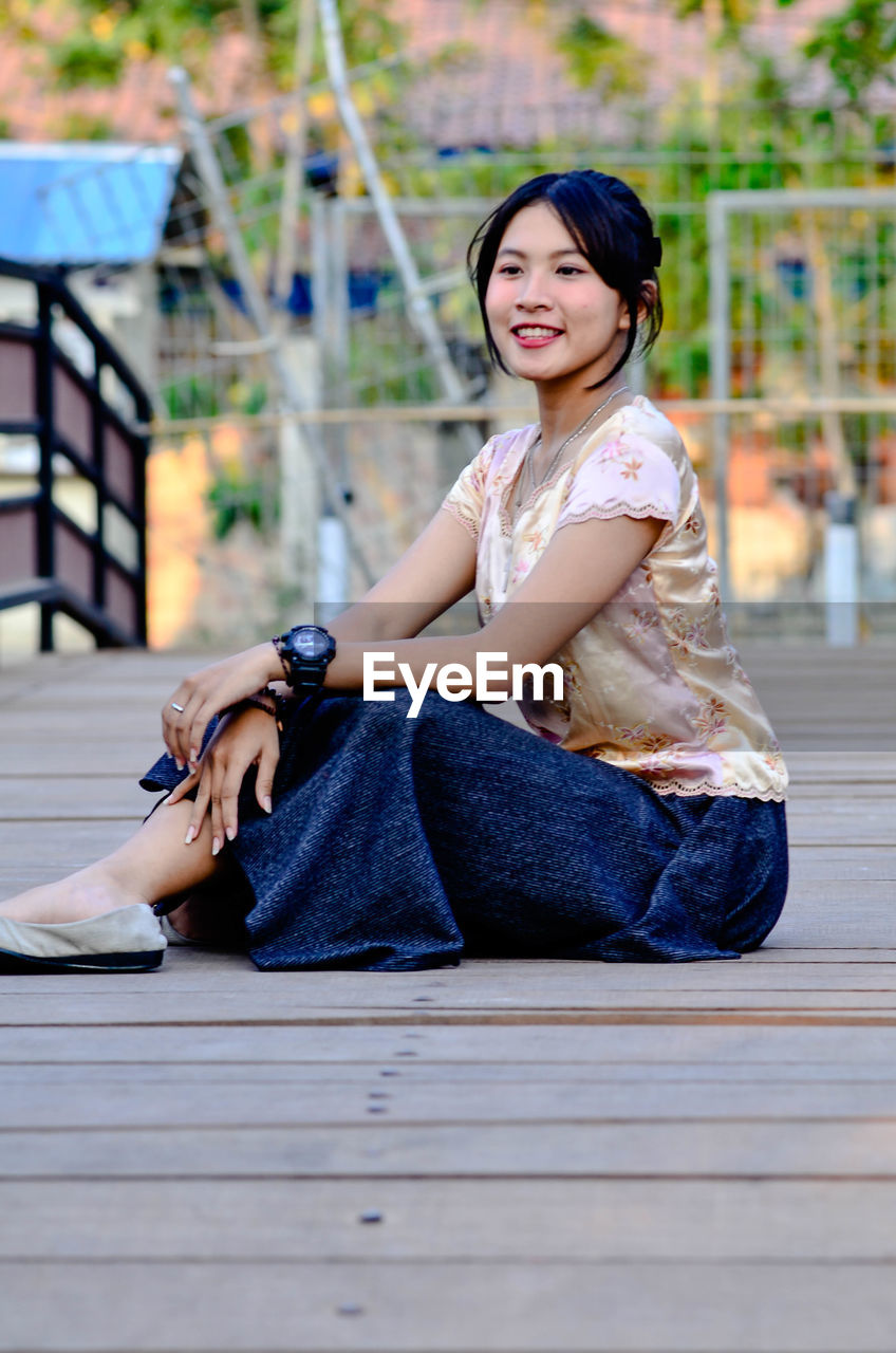 Portrait of a smiling young woman sitting outdoors